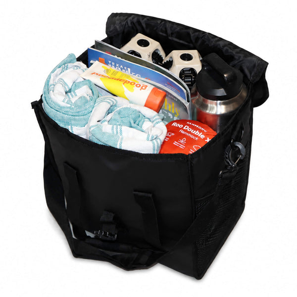 A black soft-sided bag filled with travel items, including a light blue and white striped towel, a water bottle, a thermos, and packaged snacks, shown on a white background. - X-Large Chair Tote Bag