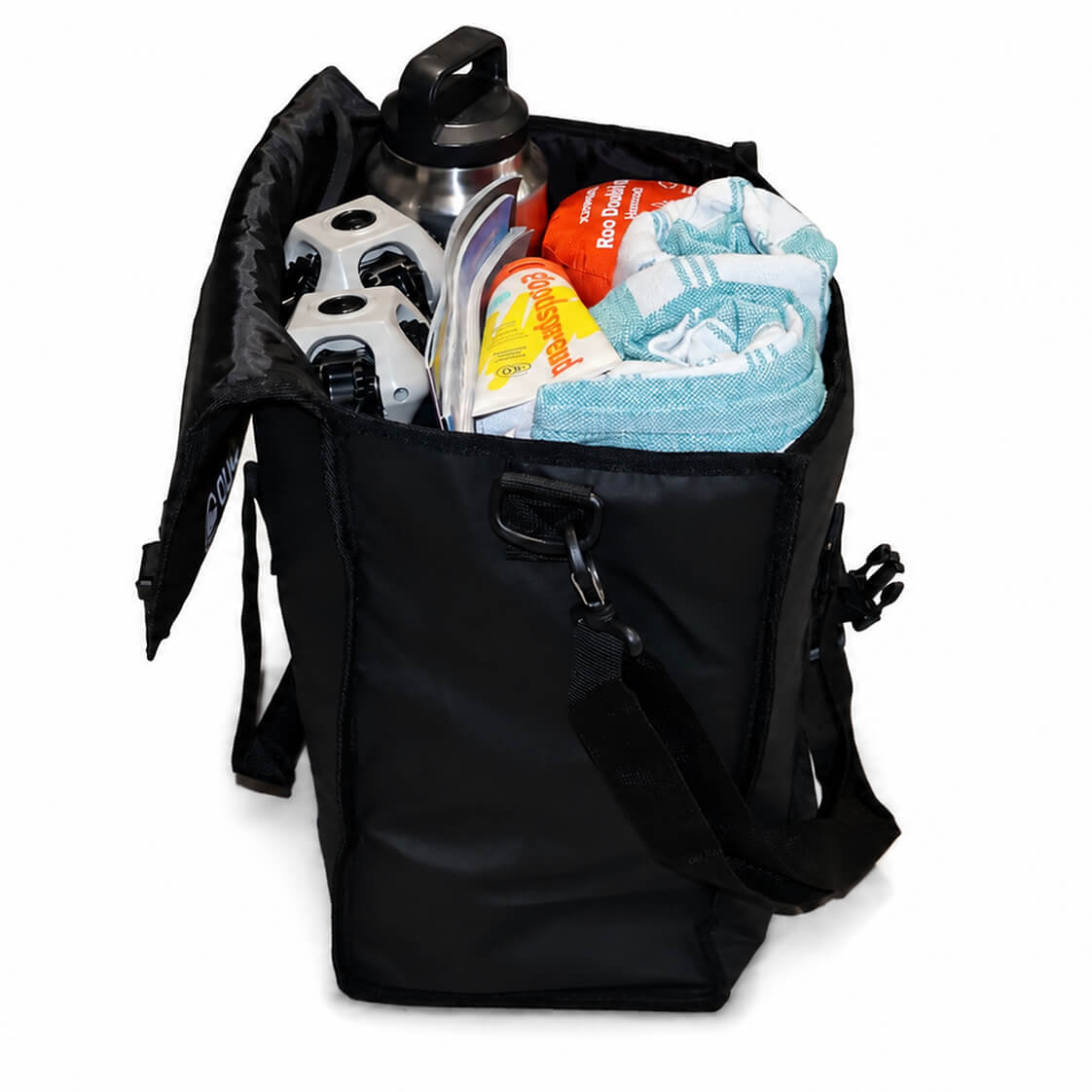 A black soft-sided cooler bag shown open on a white background, filled with a stainless steel water bottle, a white and black travel mug, a folded light blue towel, and packaged snacks. - X-Large Chair Tote Bag