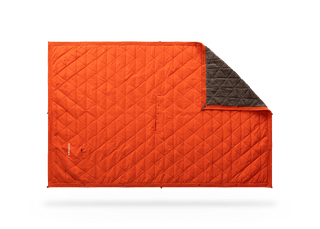 Kammok Mountain Blanket in Ember Orange, laid flat with a corner folded