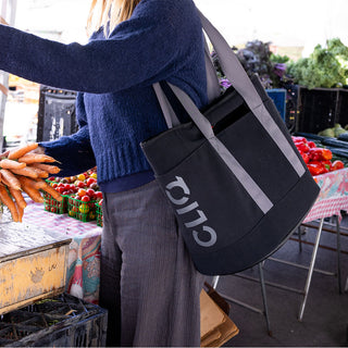 Person shopping at a farmers market with a black CLIQ tote bag