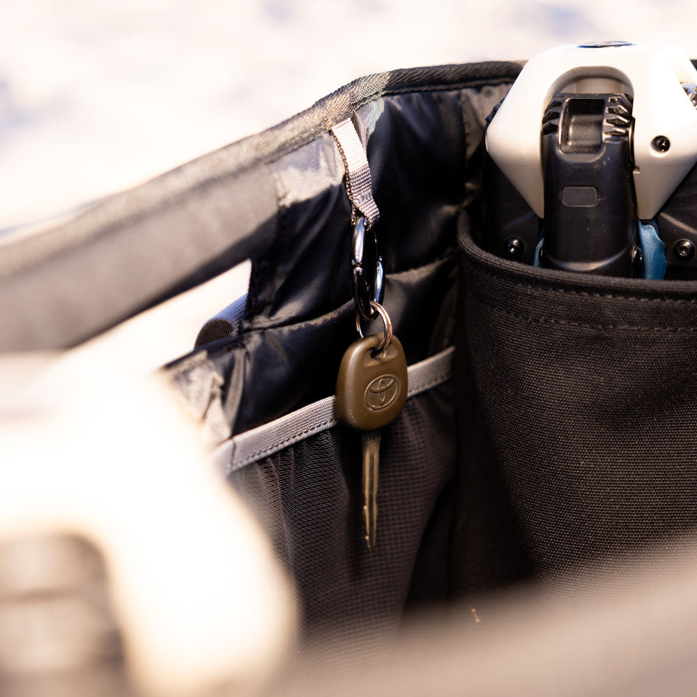 Black bag with a key and electronic device inside, blurred background