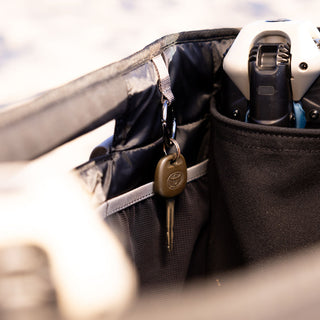 Black bag with a key and electronic device inside, blurred background
