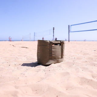 Olive tote bag on a sandy beach with volleyball net in the background - CLIQ ToQ Bag